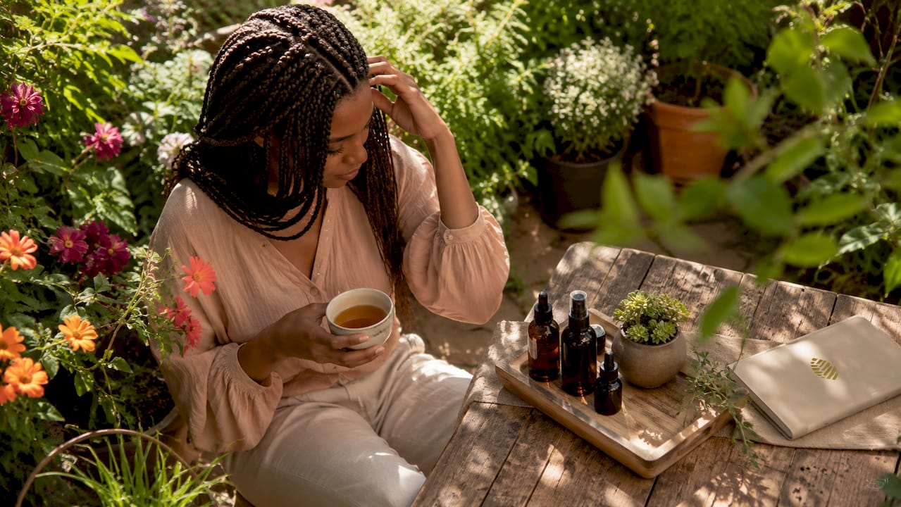 Woman with box braids gently touching hair indoors