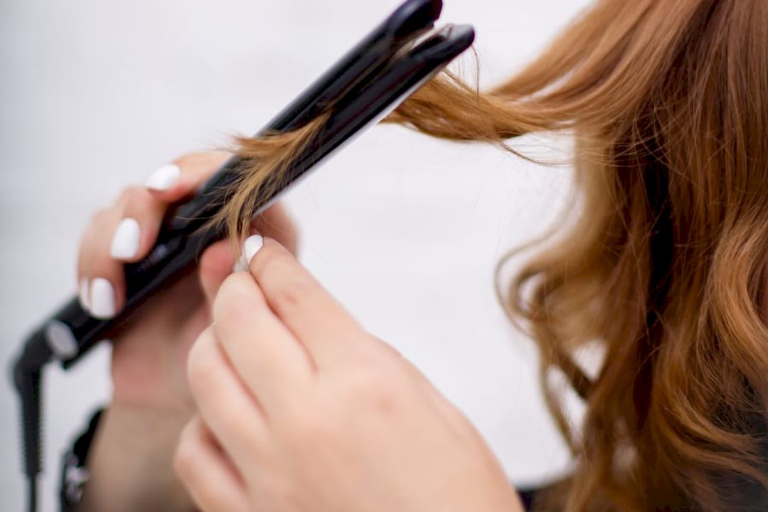 Haircare professional applying heat protectant oil