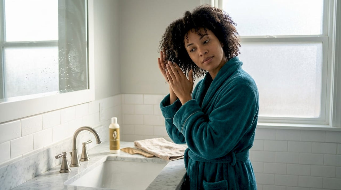 Woman wet styling curly afro hair in bathroom