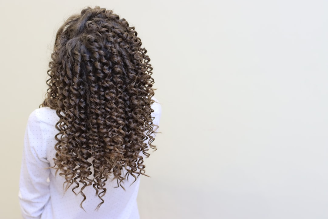 Woman applying curly hair product at kitchen table