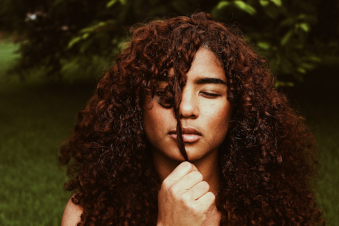 Woman air drying curly hair at kitchen table