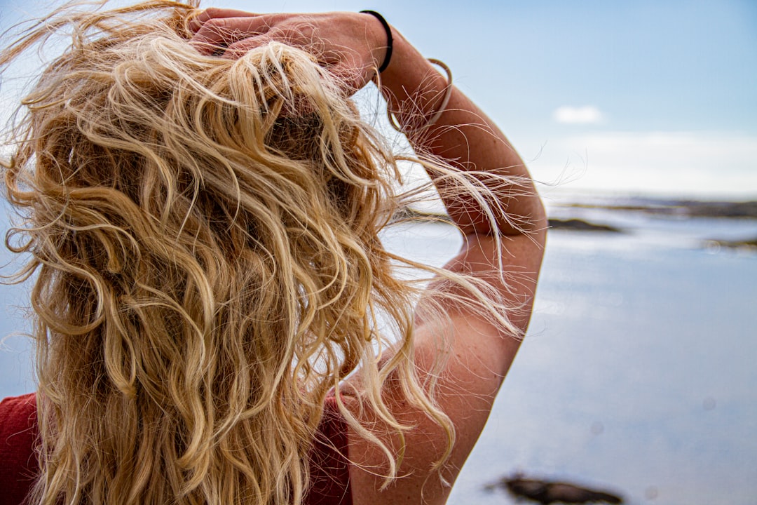 Woman applying silicone-free hair product at kitchen table