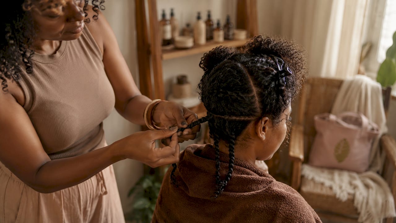 Woman styling curly hair with two-strand twists