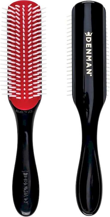 Woman brushing curly hair with Denman brush